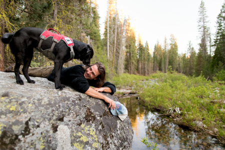 Field technician Caleb Staneck and scent detection dog (canis lupus familiaris) Winne take a rest during field work in California’s Sierra Nevada mountains. surveying for Pacific fisher, which is under consideration as an endangered species. The team is part of University of Washington Center for Conservation Biology’s Conservation Canines program.